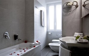 Et moderne badeværelse med badekar, toilet og håndvask.