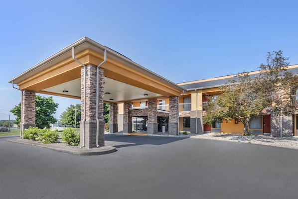 A hotel with a covered outdoor area, multiple floors, and a brick facade.