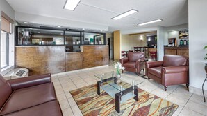 A lobby with leather seating, a glass coffee table, and a reception area with a counter. - Quality Inn Glasgow (Glasgow)
