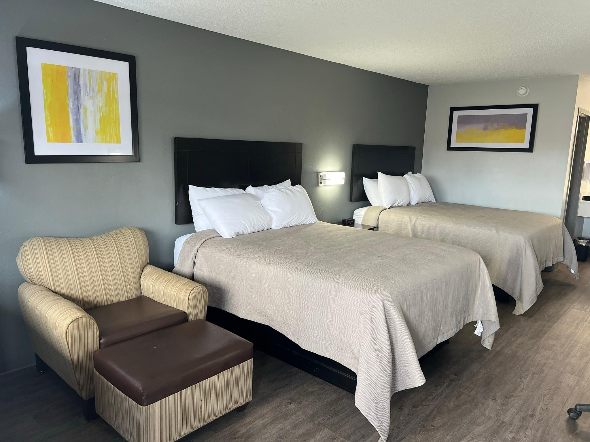 Una habitación de hotel con dos camas, un sofá y una mesita.