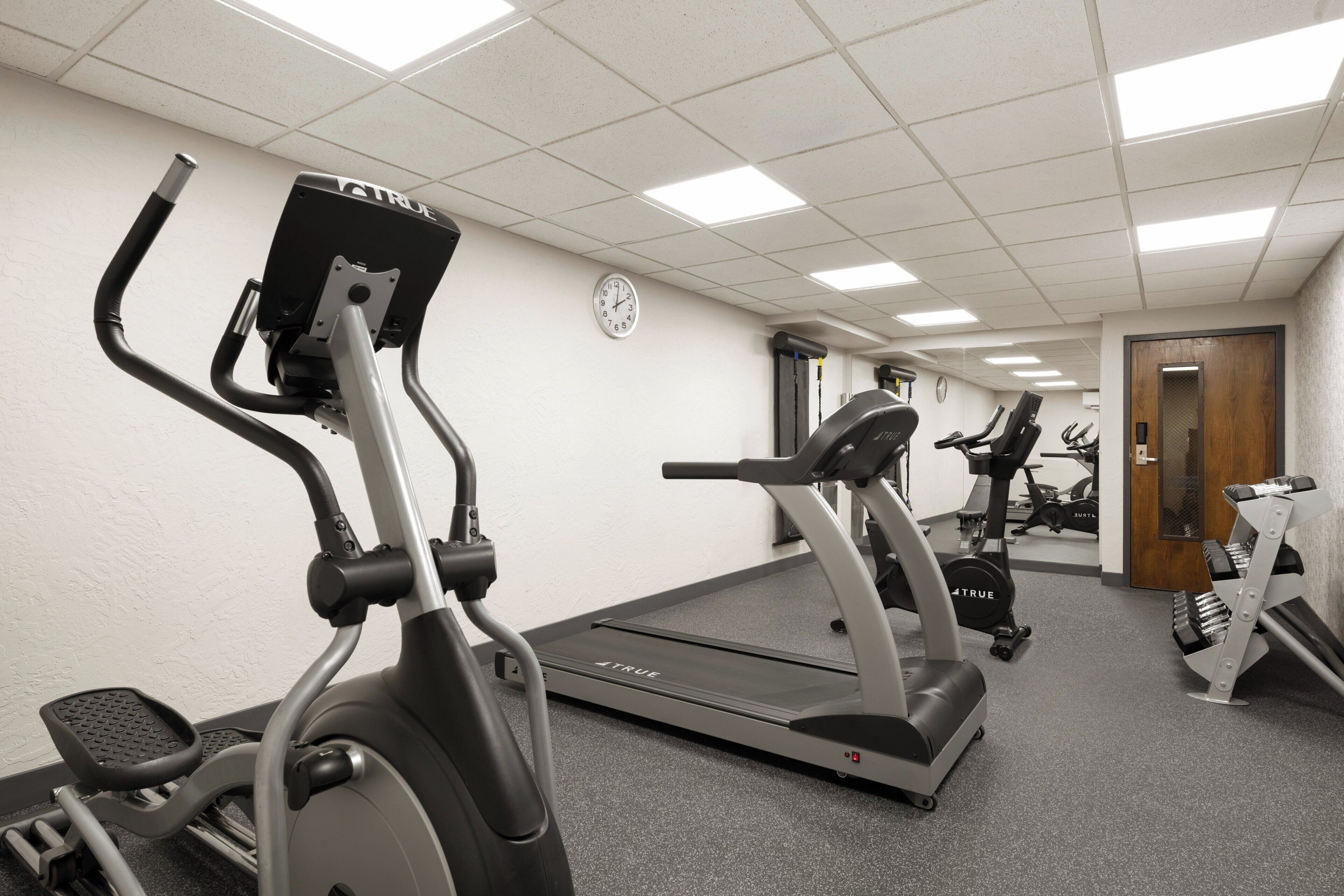 Uma academia com bicicletas ergométricas, esteiras e equipamentos de ginástica.