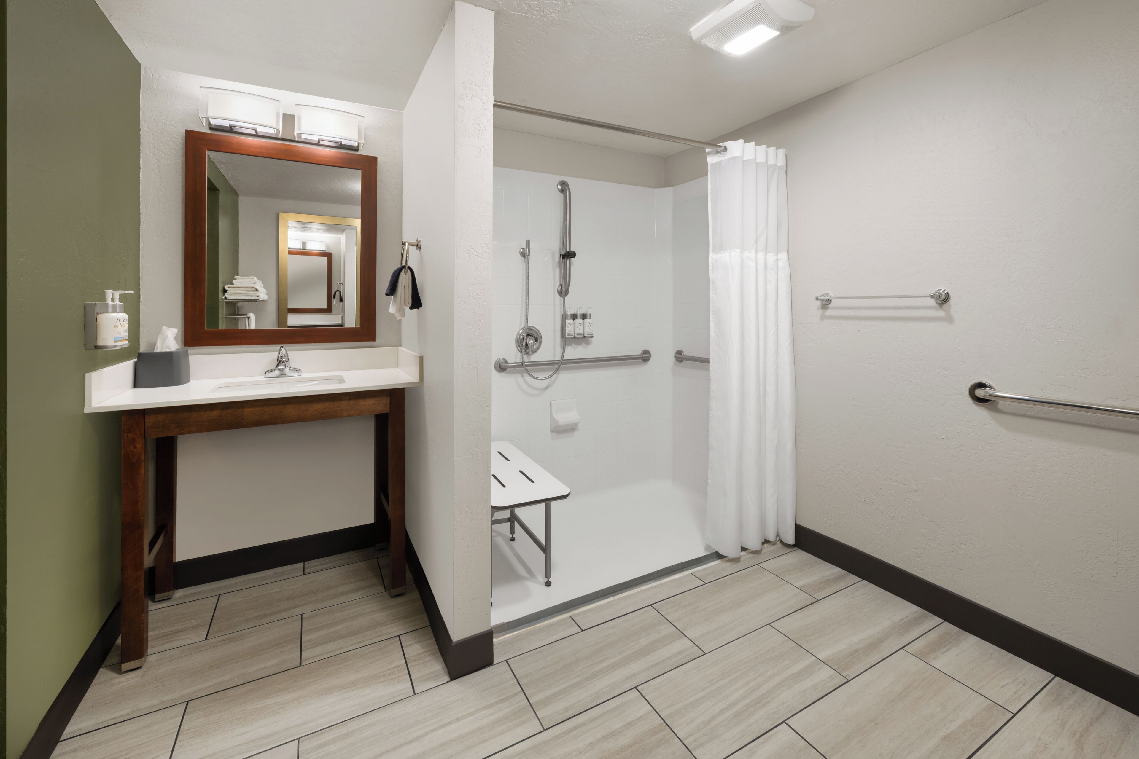 A modern bathroom with a shower, a sink with a mirror, and a towel rack.