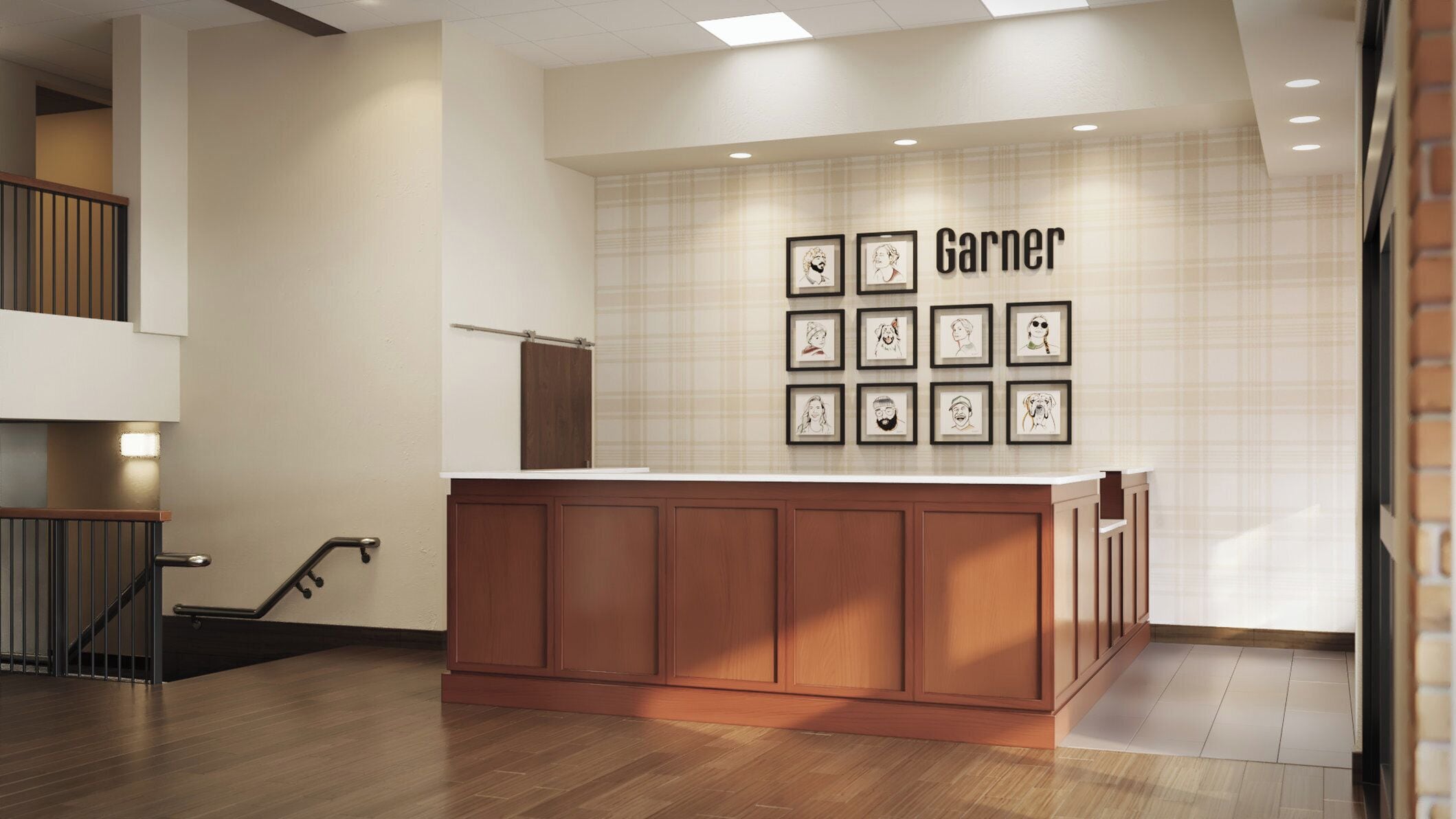 A hotel lobby with a reception desk, a staircase, and a wall with framed artwork.