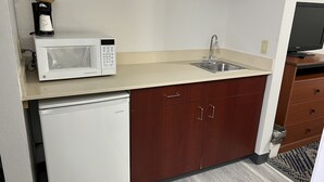 A compact kitchenette with a microwave, sink, and small refrigerator. - Baymont by Wyndham Omaha SW (Omaha)