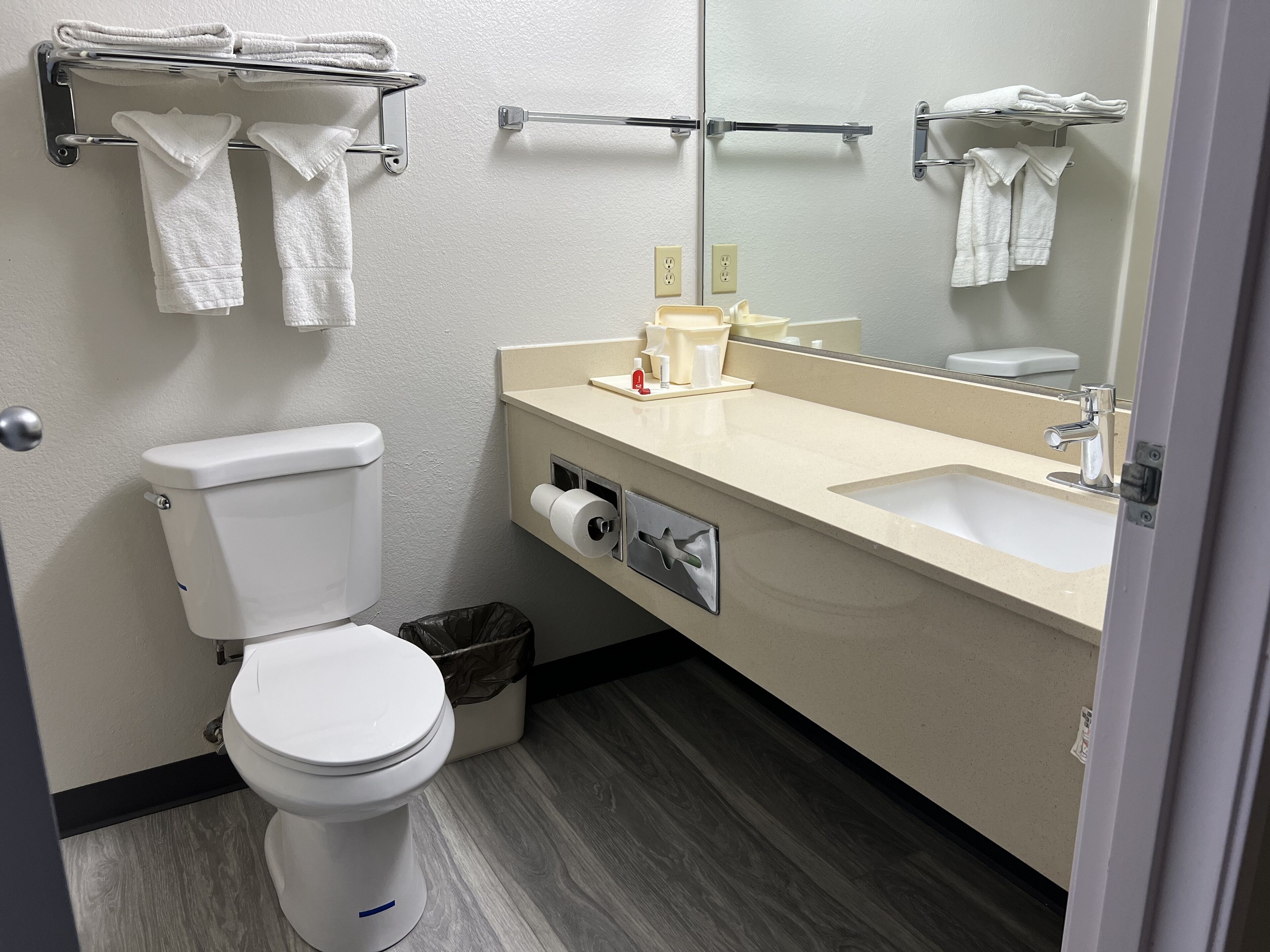 Une salle de bain moderne équipée de toilettes, d’un lavabo et d’un porte-serviettes.