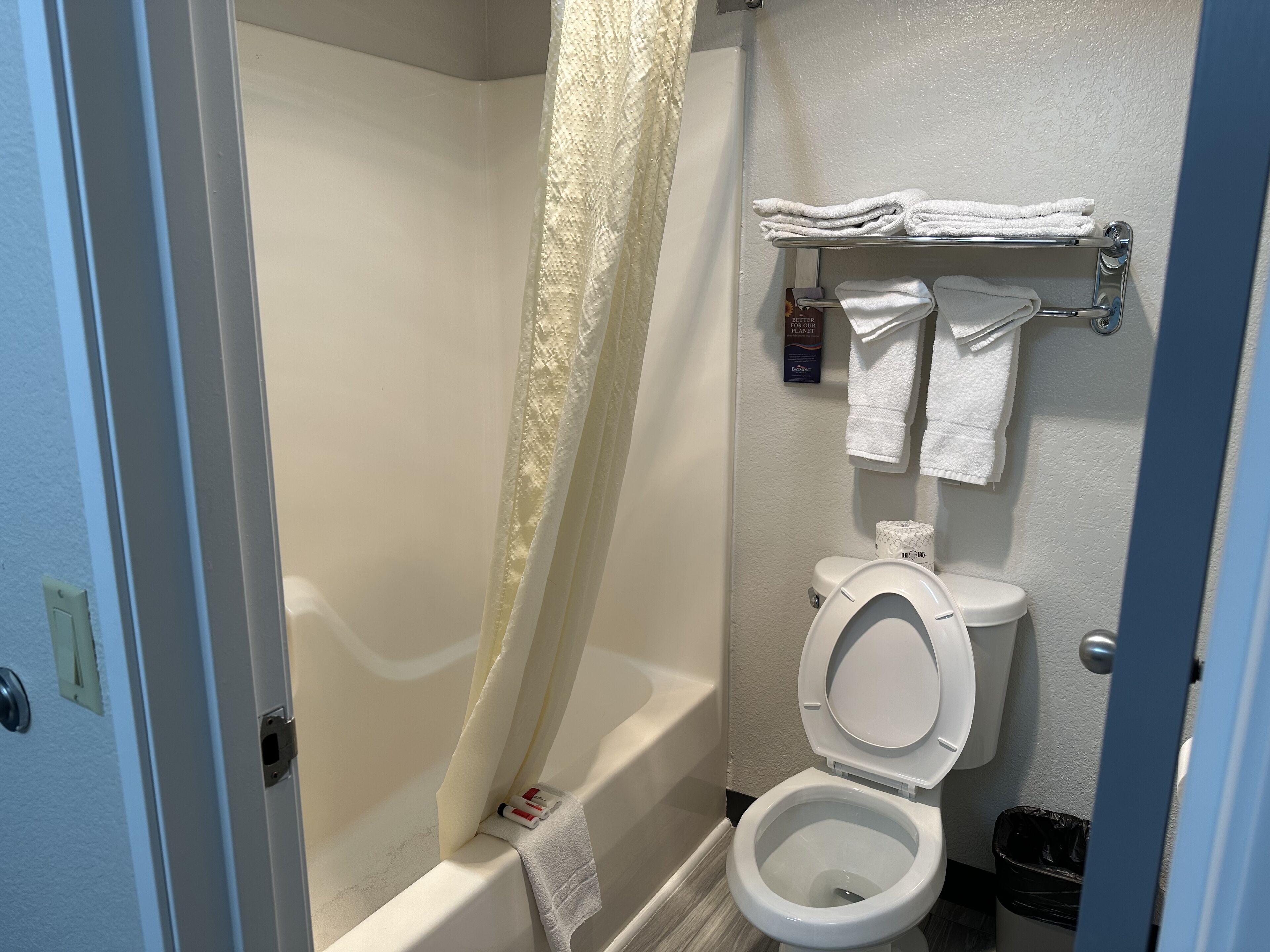 A bathroom with a bathtub, toilet, and a towel rack.