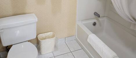 A bathroom with a toilet, a bathtub, and a shower curtain.