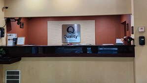 Ein Hotelrezeptionstresen mit einem Schild, auf dem ‘Quality by Choice Hotels’ steht.