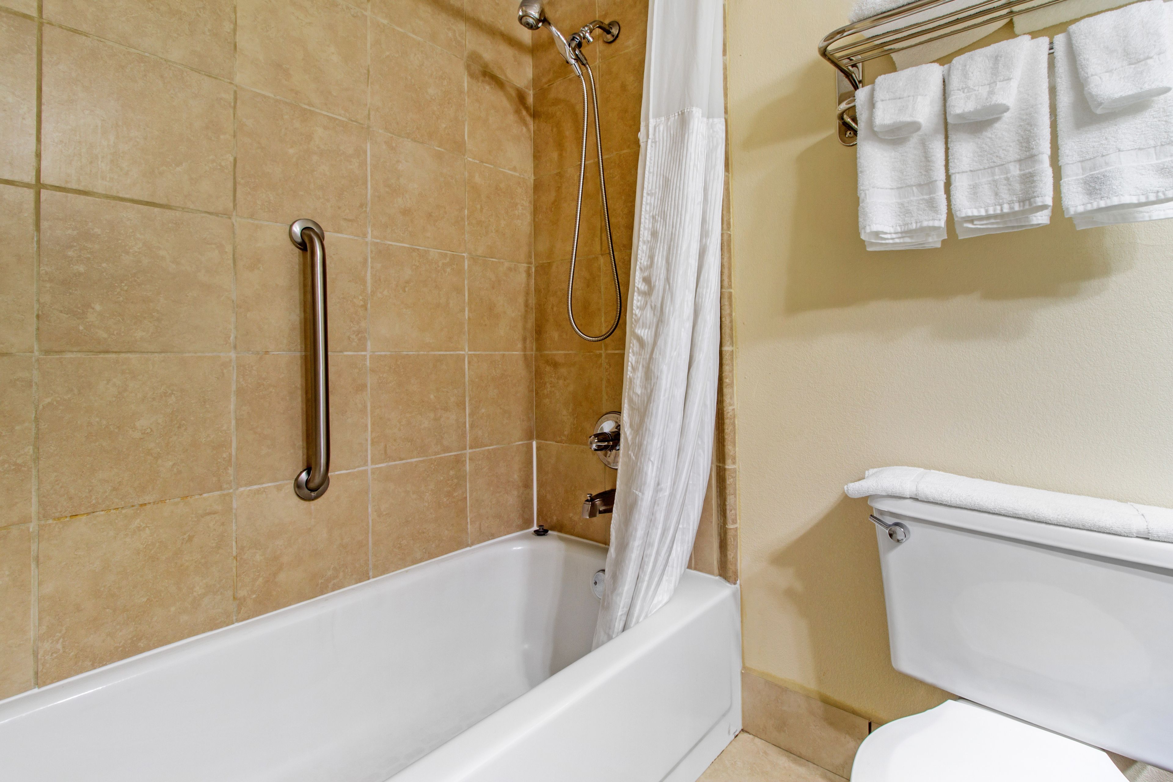 Un baño con bañera, ducha e inodoro.