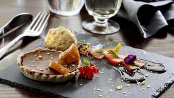 A dessert plate with a tart, berries, and a small tart on a slate board.