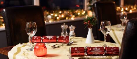 A dining table set with a tablecloth, cutlery, and a candle.
