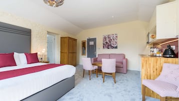 A bedroom with a bed, a desk, a chair, a sofa, and a wardrobe.