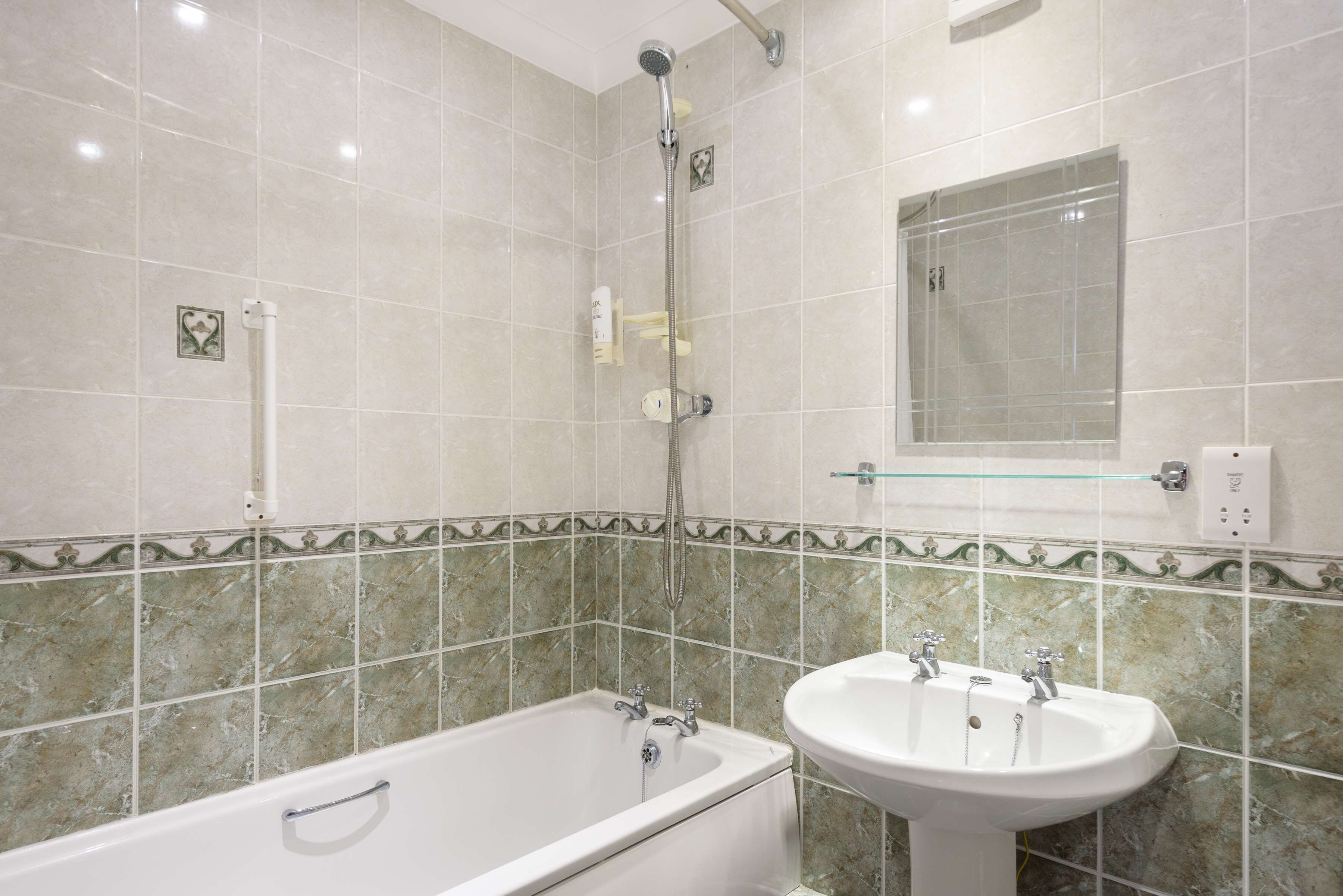 Un baño con bañera, lavabo y ducha.