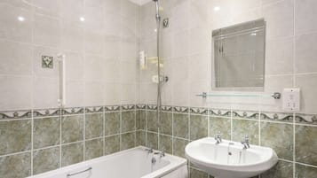 Un baño con bañera, lavabo y ducha.