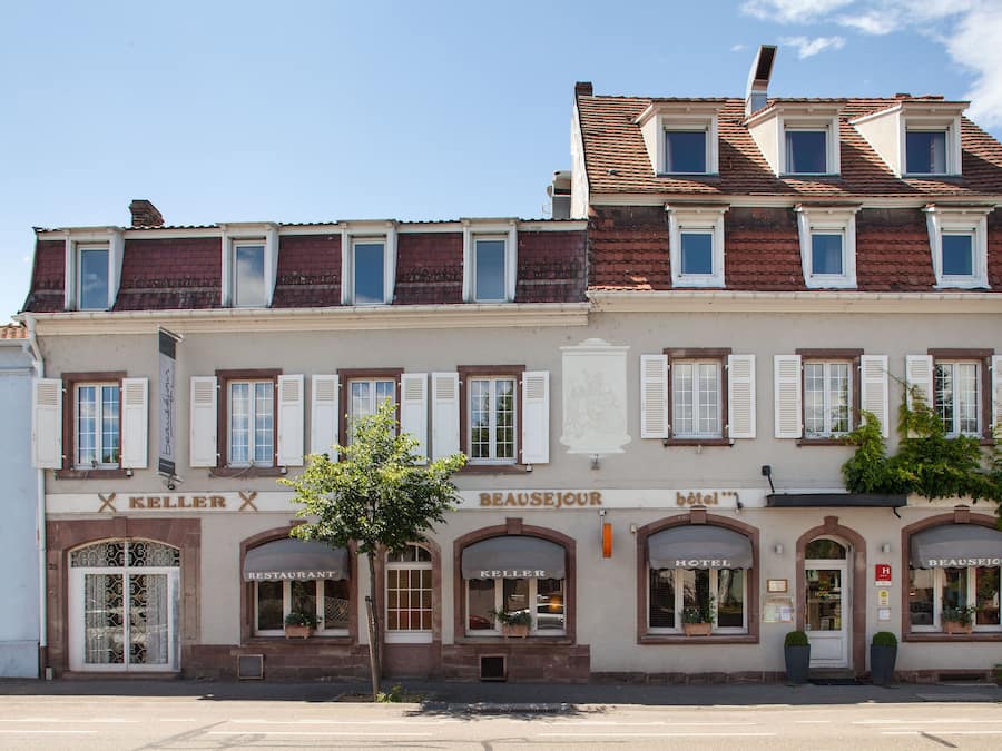 A multi-story building with a restaurant named 'Keller' on the ground floor and a hotel named 'Beausejour' on the upper floor.