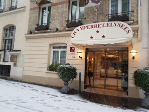 Entrada de un hotel con un letrero que dice 'CHAMPERRETT ELYSEES'.