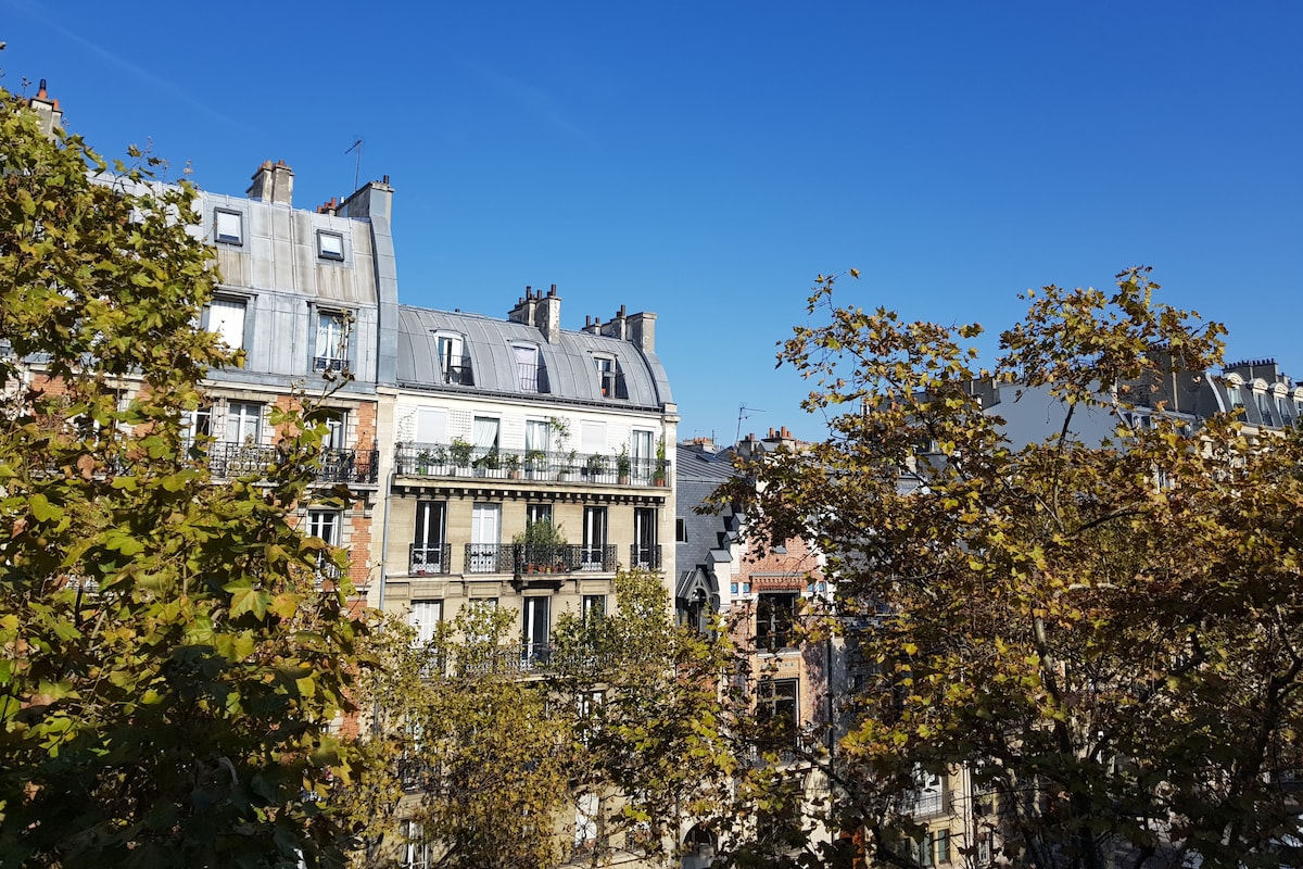A multi-story building with a classic European architectural style, featuring a mix of stone and plaster facades, large windows, and balconies.