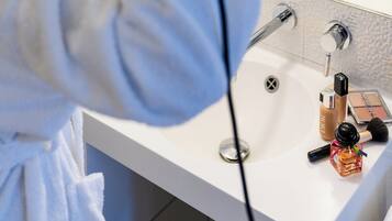 A bathroom with a sink, mirror, and various toiletries.