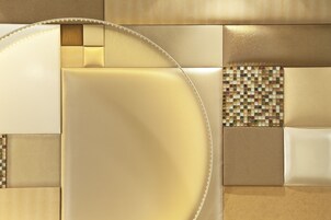 A modern interior with a curved seating area, a patterned tile wall, and a neutral color scheme.