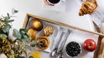 Uma bandeja com doces, uma xícara de café e um limão.