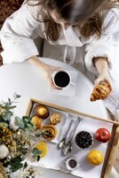 A tray with pastries, a cup of coffee, and a lemon.