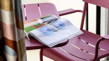 Guests can sit and read in style with a comfortable chair and a magazine featuring sunglasses.