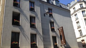 A hotel building with multiple windows, some with flower boxes. A sign indicates it's the Hotel Elysees. - Hotel Elysées Flaubert (Paris)