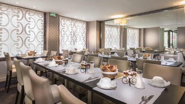 A conference room with multiple tables set for a meeting, equipped with nameplates, notepads, and pens. - Hotel Elysées Flaubert (Paris)