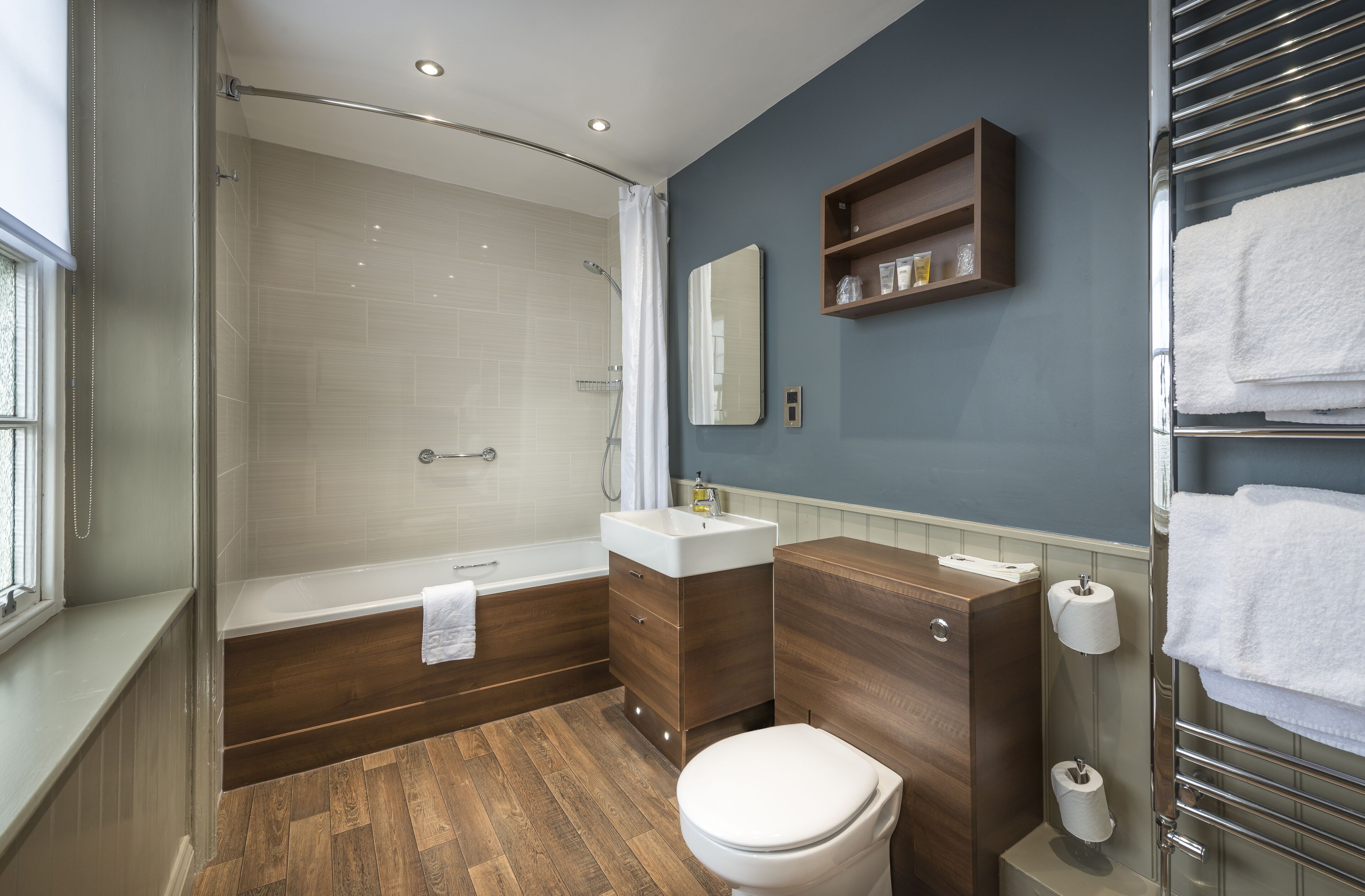 A modern bathroom with a shower, toilet, and sink.