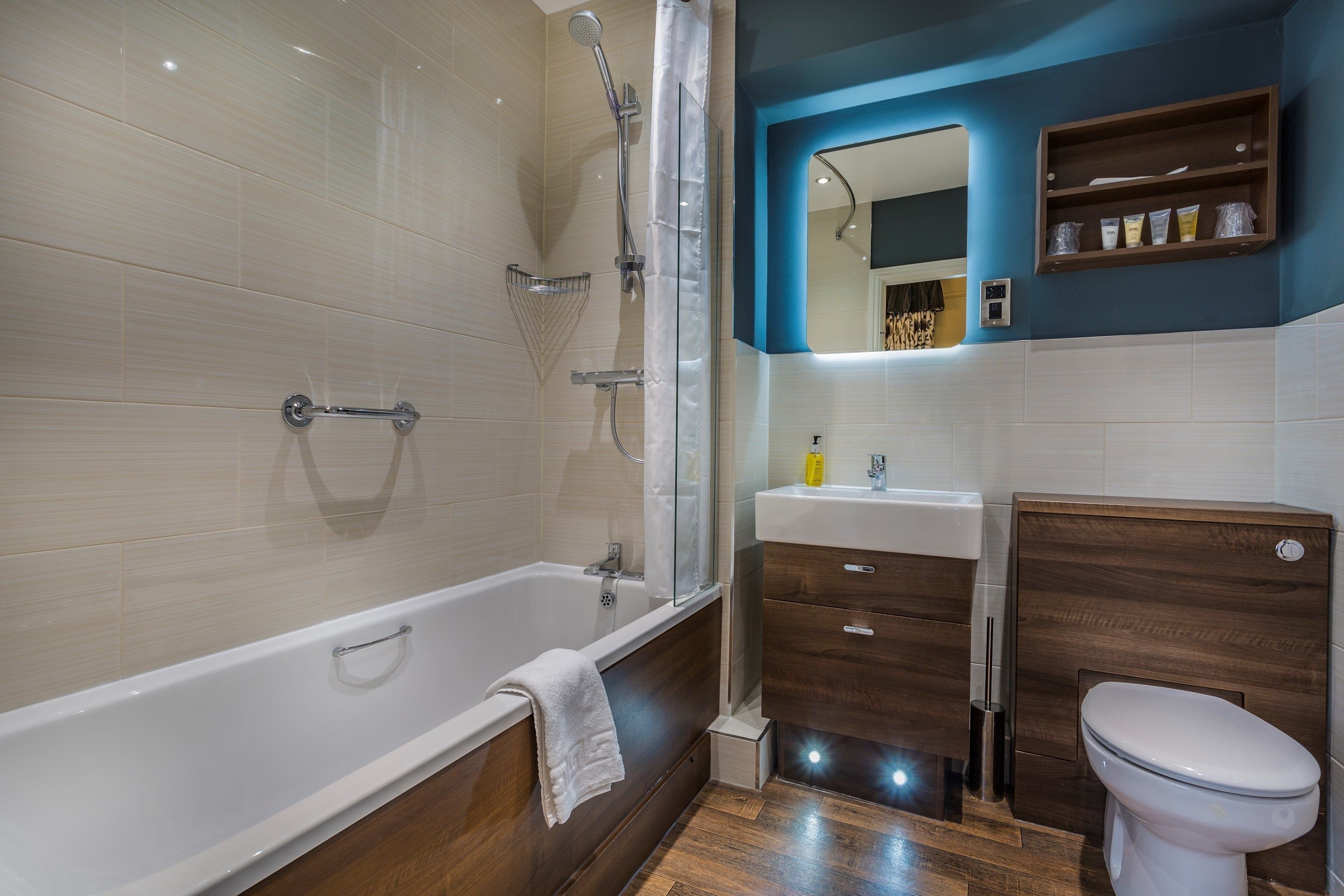 A modern bathroom with a bathtub, shower, vanity, and toilet.