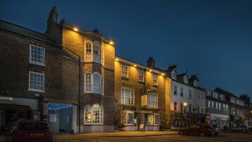 A historic building with a pub named 'The Golden Lion' at its entrance, featuring a traditional brick facade and multiple windows.