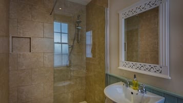 A bathroom with a shower, a sink, and a mirror.