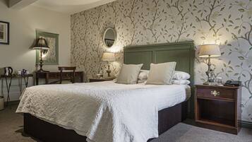 A neatly arranged bedroom with a large bed, two bedside tables, and a mirror.
