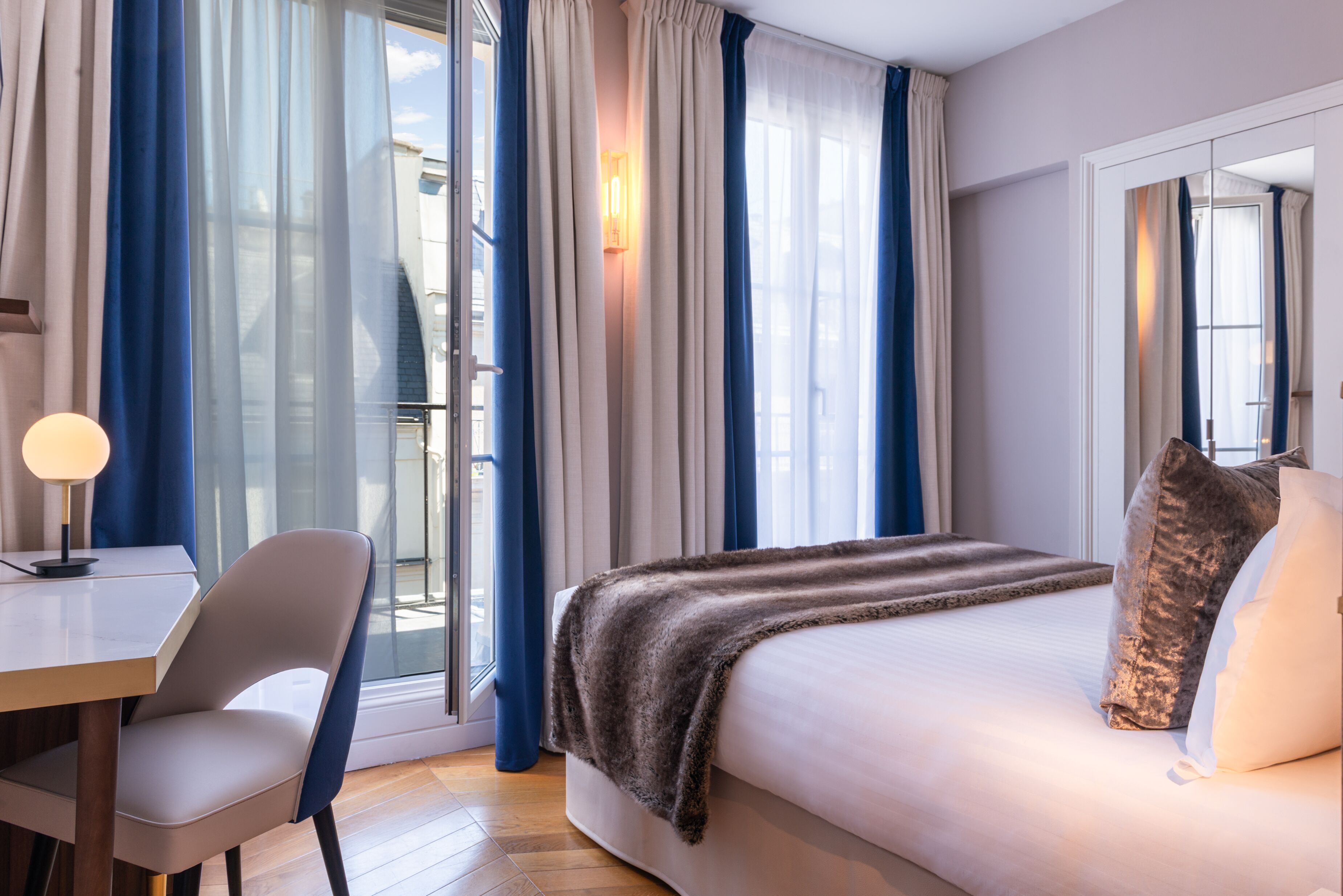 Ein Hotelzimmer mit Bett, Schreibtisch und Stuhl.