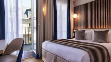 Een hotelkamer met een groot bed, een stoel, een balkon en een modern wandontwerp.