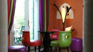 A dining area with a table and chairs, a window with curtains, and a wall-mounted light fixture.