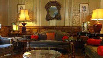 Una habitación con sofá, sillones, una mesa de centro y lámparas.