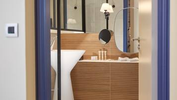 Un baño moderno con tocador de madera, un lavabo blanco y un espejo.