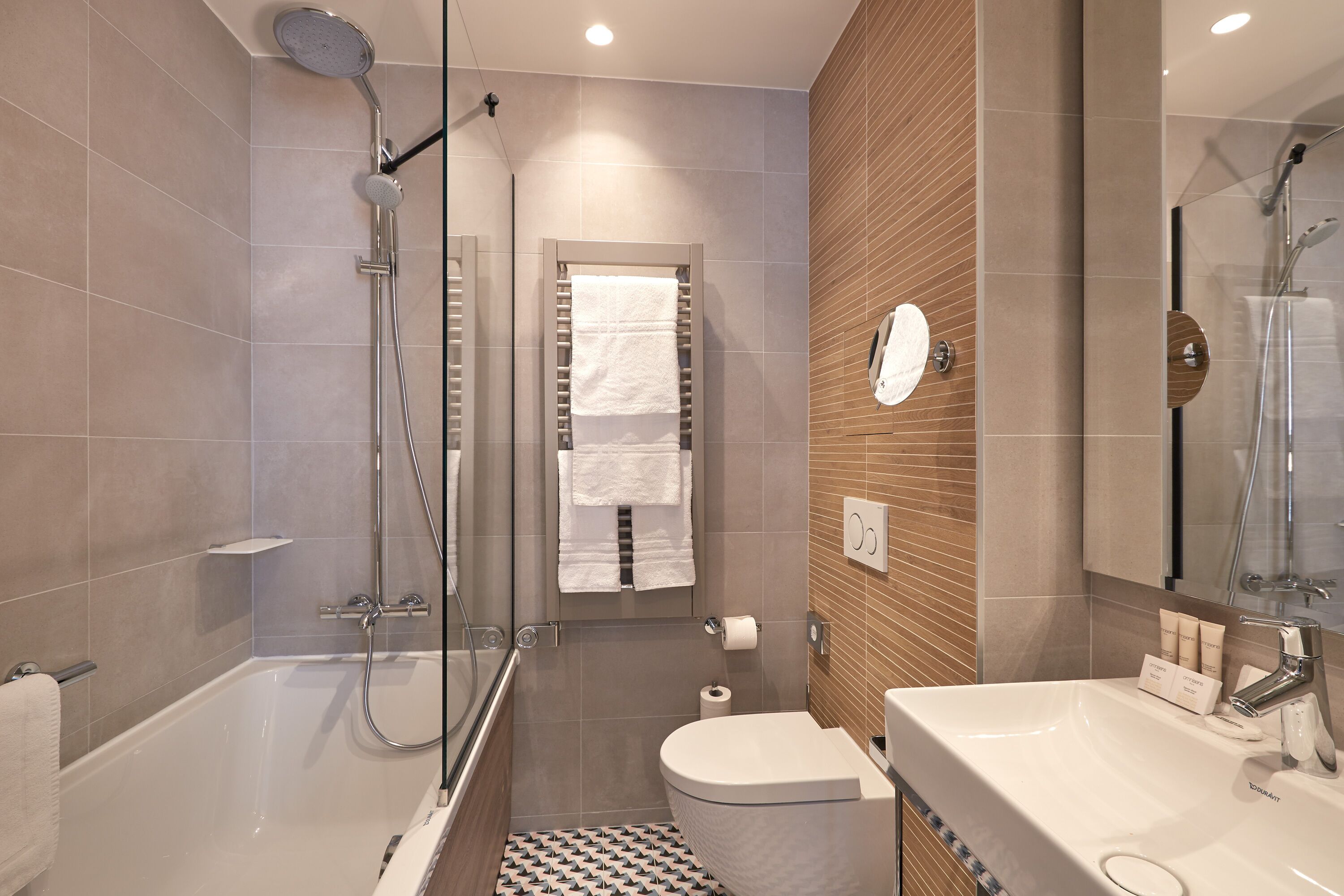 A modern bathroom with a bathtub, shower, and toilet.
