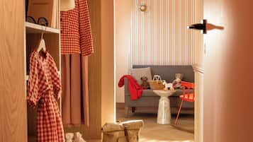 A room with a sofa, a small table, a teddy bear, and a chair.