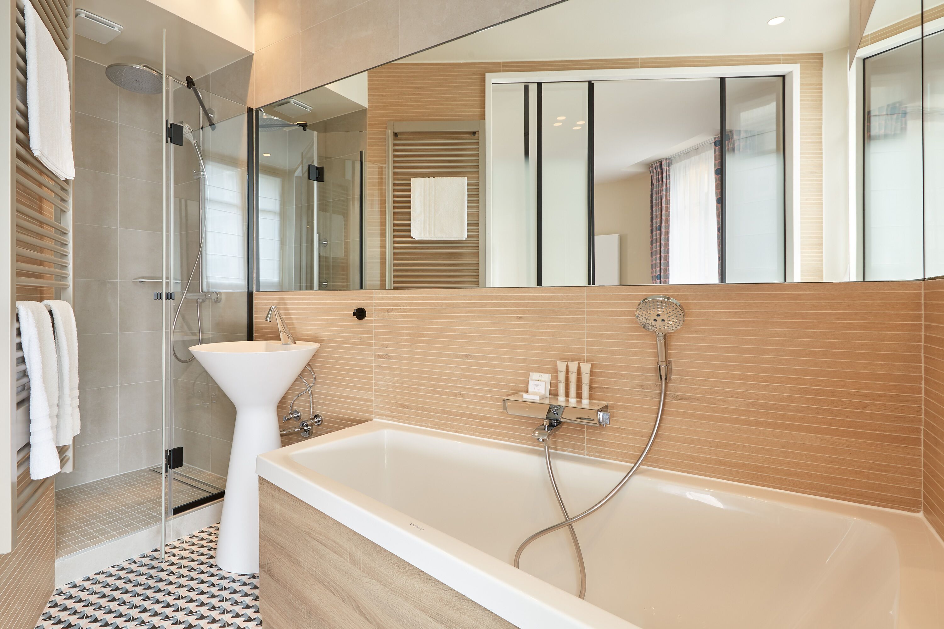 A modern bathroom with a bathtub, shower, and sink.