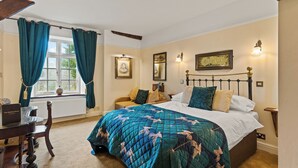 Ein Schlafzimmer mit einem Bett, einem Schreibtisch und einem Fenster mit Vorhängen.