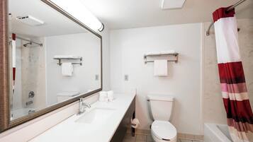 Un baño con lavamanos blanco, un espejo, inodoro y cortina de ducha.