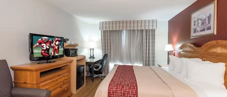 A hotel room with a bed, a TV, a desk, and a chair.