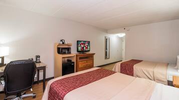 A hotel room with two beds, a desk with a chair, a television, and a microwave.