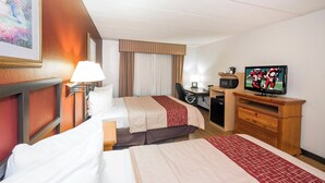 A hotel room with two beds, a desk, a television, and a painting on the wall. - Red Roof Inn & Suites Stafford, VA - Quantico (Stafford)