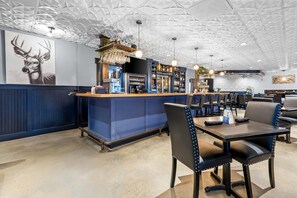 A restaurant interior with a bar area, seating, and a decorative ceiling.