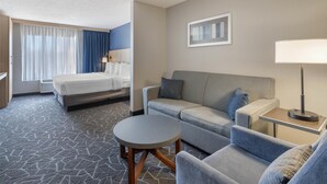 A hotel room with a bed, a sofa, a small table, and a lamp. - Best Western Eau Claire South (Eau Claire)