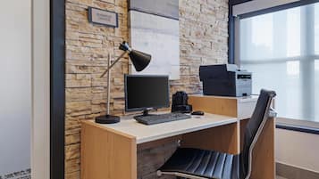 A modern office desk with a computer, a lamp, and a printer.