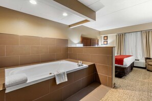 A modern bathroom with a large bathtub, a shower area, and a vanity with a mirror. - Comfort Inn & Suites Hamilton Place (Chattanooga)